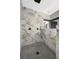 Marble-tiled shower with modern fixtures and gray tiled floor at 10130 Deercliff Dr, Tampa, FL 33647