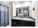 Bathroom with double sinks, granite countertop, dark cabinets, and a shower at 10229 Bright Crystal Ave, Riverview, FL 33578
