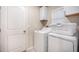 Laundry room with white washer, dryer, white cabinets, and white door at 10229 Bright Crystal Ave, Riverview, FL 33578