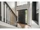 Inviting entryway with wood-look flooring, a black front door with sidelights and an open staircase with black railings at 10308 Boyette Creek Blvd, Riverview, FL 33569