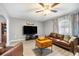 A comfortable living room features wood floors, a leather sofa and entertainment center at 10308 Boyette Creek Blvd, Riverview, FL 33569