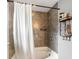 Tiled shower showcasing a shower head, a bath tub, a shower curtain, and built-in shelving for toiletries at 10308 Boyette Creek Blvd, Riverview, FL 33569