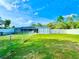 Expansive backyard featuring a screened pool area, lush green lawn, and a secure fenced perimeter at 11268 Shivering Owl Ave, Weeki Wachee, FL 34614
