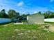 Spacious backyard featuring a utility shed, car port, and white vinyl fencing at 11268 Shivering Owl Ave, Weeki Wachee, FL 34614