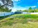 Expansive backyard featuring a screened pool area, lush green lawn, and a secure fenced perimeter at 11268 Shivering Owl Ave, Weeki Wachee, FL 34614