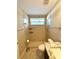 Bright bathroom featuring a walk-in shower with tiled walls and a window for natural light at 11268 Shivering Owl Ave, Weeki Wachee, FL 34614