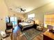 Cozy bedroom with wood floors, ceiling fan, and access to outdoor pool area at 11268 Shivering Owl Ave, Weeki Wachee, FL 34614