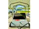 Carport with a lawn sweeper and chairs overlooking the house and yard at 11268 Shivering Owl Ave, Weeki Wachee, FL 34614
