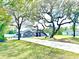 Landscaped front yard with mature trees and a long driveway leading to a well-maintained home at 11268 Shivering Owl Ave, Weeki Wachee, FL 34614