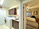 Laundry room view into a bedroom with modern appliances, granite countertops, and cabinets at 11268 Shivering Owl Ave, Weeki Wachee, FL 34614
