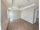 Inviting primary bedroom with wood floors, tray ceiling, and a ceiling fan at 12604 Montford Ln, Riverview, FL 33579