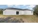 Back exterior of home with covered patio and grassy area, trees at 13451 Kaplan Ter, Port Charlotte, FL 33981