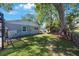 Large backyard with lush green grass, a privacy fence, and mature trees offering shade at 1422 Pinebrook Dr, Clearwater, FL 33755