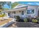 Charming home featuring a cozy front porch with stylish seating and well-maintained landscaping at 1422 Pinebrook Dr, Clearwater, FL 33755
