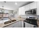 Modern kitchen with granite countertops, stainless appliances, and white cabinets at 1422 Pinebrook Dr, Clearwater, FL 33755