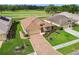 Charming aerial view of a home boasting a beautifully landscaped yard, concrete driveway, and lush lawn at 17425 Eagle Trace Dr, Brooksville, FL 34604