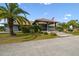 Clubhouse with covered entrance, American flag, lush landscaping, and ample parking at 17425 Eagle Trace Dr, Brooksville, FL 34604