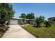 Home exterior with a well-maintained lawn, a paved driveway, and lush landscaping at 1942 Ashland Dr, Clearwater, FL 33763