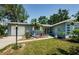 Charming single-story home with a well-manicured lawn and cute tropical landscaping in front at 1942 Ashland Dr, Clearwater, FL 33763