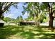 Spacious backyard with trees, a screened-in porch, fenced pool, and lush greenery at 2004 Chickwood Ct, Tampa, FL 33618