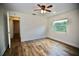 Bedroom with wood-look floors, a window, and an open doorway at 2004 Chickwood Ct, Tampa, FL 33618