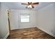 Bedroom with wood-look floors, window with blinds, and an open doorway at 2004 Chickwood Ct, Tampa, FL 33618