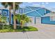 Attractive blue condo featuring a two-car garage and tropical landscaping at 2023 Golfview Dr # 2023, Tarpon Springs, FL 34689