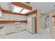 Bright kitchen with white cabinets, appliances, and tile flooring, leading to bathroom at 2023 Golfview Dr # 2023, Tarpon Springs, FL 34689
