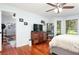 Bedroom with gleaming wood floors, large window, and a view leading to the home gym at 206 147Th E St, Bradenton, FL 34212