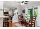 A dining area with a ceiling fan, dining table set, and an adjacent outdoor patio seen through sliding glass doors at 206 147Th E St, Bradenton, FL 34212