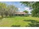 Single-story home with mature trees, lush lawn, and well-maintained landscaping at 206 147Th E St, Bradenton, FL 34212