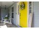 Inviting front porch featuring a bright yellow door with a charming floral wreath at 206 147Th E St, Bradenton, FL 34212