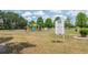 Community playground with play structures and swings, surrounded by green space and trees at 206 147Th E St, Bradenton, FL 34212