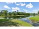 Community pond surrounded by lush green grass and an array of mature trees at 206 147Th E St, Bradenton, FL 34212