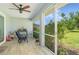 A screened back porch featuring a ceiling fan, seating, and a view of the expansive backyard at 206 147Th E St, Bradenton, FL 34212