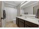 Well-lit bathroom features a dark vanity, illuminated mirror, and shower with a patterned curtain at 2109 N Jamaica St, Tampa, FL 33607