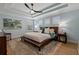 Relaxing bedroom featuring a tray ceiling, plush rug, and plantation shutters at 2109 N Jamaica St, Tampa, FL 33607