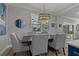 Dining area with decorative light fixture, plantation shutters, wood floors, and neutral decor at 2109 N Jamaica St, Tampa, FL 33607