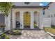 Charming front entrance with a bright yellow door, stone pathway, and meticulously kept landscaping at 2109 N Jamaica St, Tampa, FL 33607