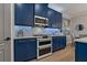Stylish kitchen featuring blue cabinets, stainless steel appliances, and white backsplash at 2109 N Jamaica St, Tampa, FL 33607