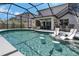 Resort-style pool with built-in bar stools and lounge chairs under a screened enclosure at 2109 N Jamaica St, Tampa, FL 33607