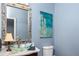 This bathroom features a glass bowl sink, marble countertop, and decorative mirror and artwork at 2111 Alexis Ct, Tarpon Springs, FL 34689