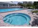 Community pool and hot tub surrounded by lounge chairs, perfect for relaxation at 2111 Alexis Ct, Tarpon Springs, FL 34689