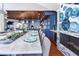 Elegant dining area adjacent to the kitchen, featuring a long marble table, wood ceiling, and fireplace at 2111 Alexis Ct, Tarpon Springs, FL 34689