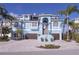 Stunning light blue two-story home featuring a two-car garage, brick driveway and elegant staircase to the front door at 2111 Alexis Ct, Tarpon Springs, FL 34689