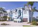 Beautiful light blue two-story home boasts a two-car garage, brick driveway, and staircase to the front door at 2111 Alexis Ct, Tarpon Springs, FL 34689