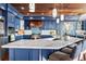 Stylish kitchen with marble countertops, custom blue cabinets, stainless steel appliances, and wood ceiling at 2111 Alexis Ct, Tarpon Springs, FL 34689