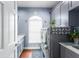 Spacious laundry room with gray cabinets, stainless steel washer and dryer, and wooden floor at 2111 Alexis Ct, Tarpon Springs, FL 34689
