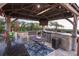 Outdoor kitchen includes bar seating, an outdoor grill, mini fridges and storage at 2111 Alexis Ct, Tarpon Springs, FL 34689
