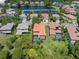 Aerial view of beautiful homes near a pond, featuring backyard pools and surrounded by mature trees and lush landscaping at 2671 Lakebreeze S Ln, Clearwater, FL 33759